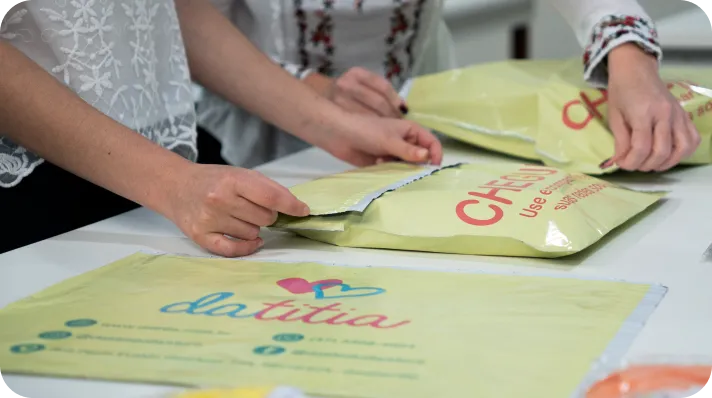 Equipe da Datitia embalando pedidos em envelopes amarelos da marca